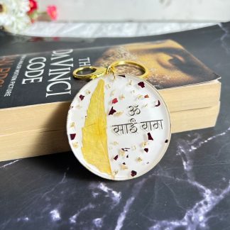Resin keychain (bag charm) with preserved leaf and 'Om Sai Ram' text