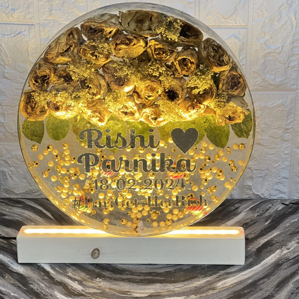 12-inch round resin frame with wedding garland flowers and white pearls on LED wooden stand